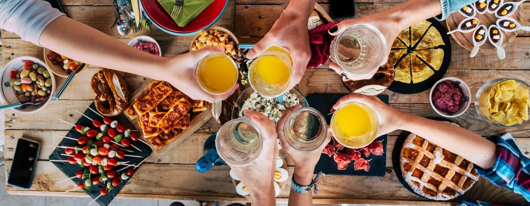 a group of people holding glasses over top of food